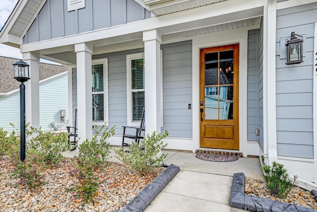 view of exterior entry featuring a porch and board and batten siding