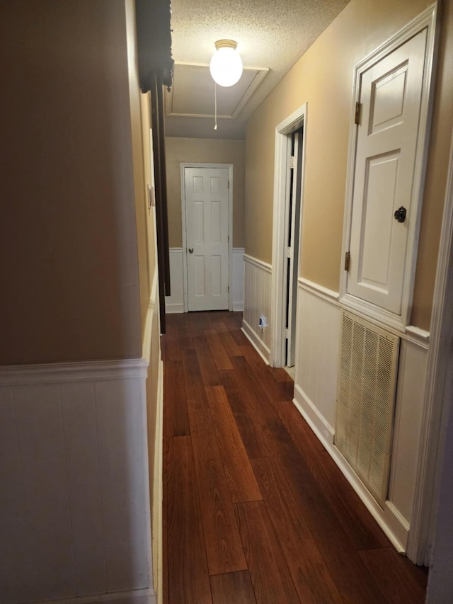 corridor featuring dark hardwood / wood-style flooring and a textured ceiling