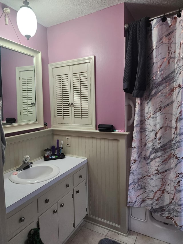 bathroom with vanity, a textured ceiling, and tile patterned floors