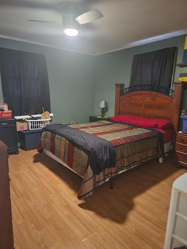 bedroom featuring hardwood / wood-style flooring, ceiling fan, and ornamental molding