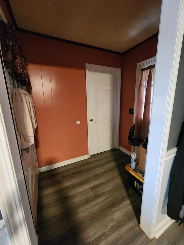 hallway with dark hardwood / wood-style flooring and crown molding