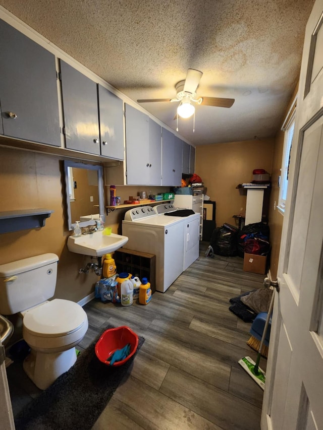 laundry area featuring ceiling fan, sink, dark wood-type flooring, a textured ceiling, and washer and clothes dryer