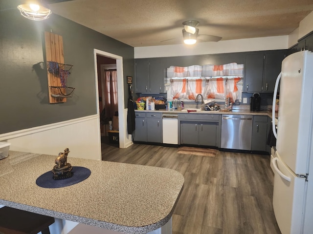 kitchen with dishwasher, sink, ceiling fan, white fridge, and kitchen peninsula