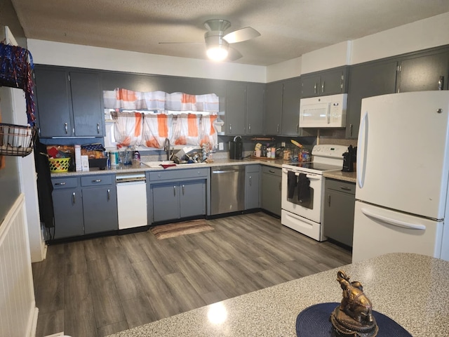 kitchen featuring white appliances, ceiling fan, sink, gray cabinets, and dark hardwood / wood-style floors