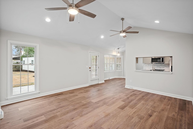 unfurnished living room featuring ceiling fan, lofted ceiling, and light wood-type flooring