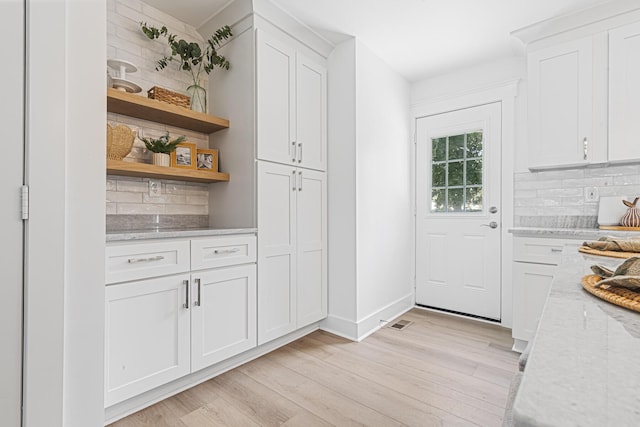 2020 Piper Dr, Charleston, SC 29407 - kitchen with decorative backsplash, open shelves, white cabinets, light wood finished floors, and light stone counters