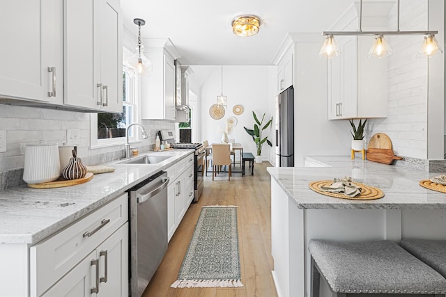 2020 Piper Dr, Charleston, SC 29407 - kitchen featuring stainless steel appliances, tasteful backsplash, light wood-type flooring, white cabinets, and light stone countertops