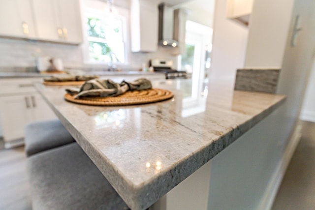 2020 Piper Dr, Charleston, SC 29407 - kitchen featuring white cabinets, a peninsula, light stone countertops, a kitchen breakfast bar, and decorative backsplash