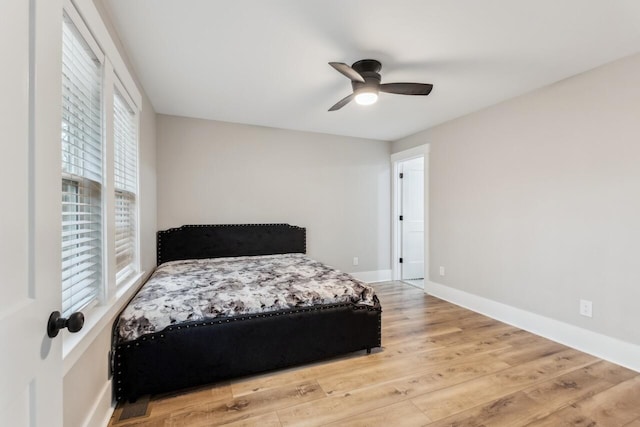 bedroom featuring multiple windows, hardwood / wood-style floors, and ceiling fan