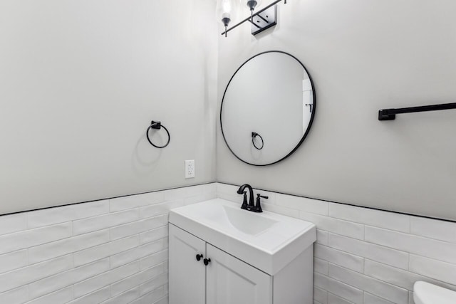 bathroom featuring vanity and tile walls