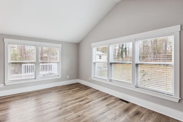 empty room featuring lofted ceiling and light wood-type flooring