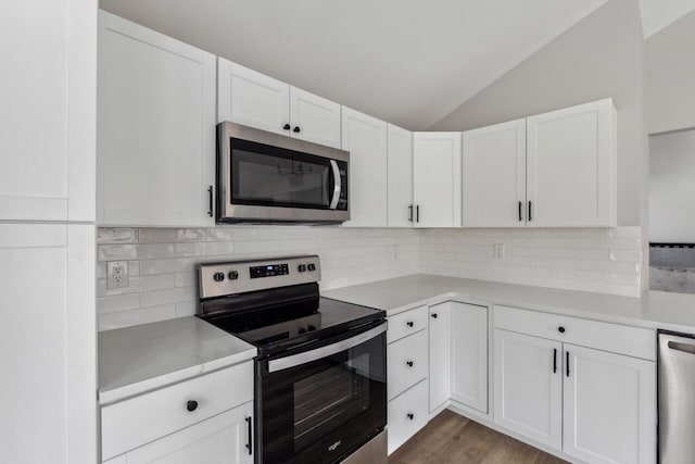 kitchen featuring lofted ceiling, tasteful backsplash, light hardwood / wood-style flooring, appliances with stainless steel finishes, and white cabinets