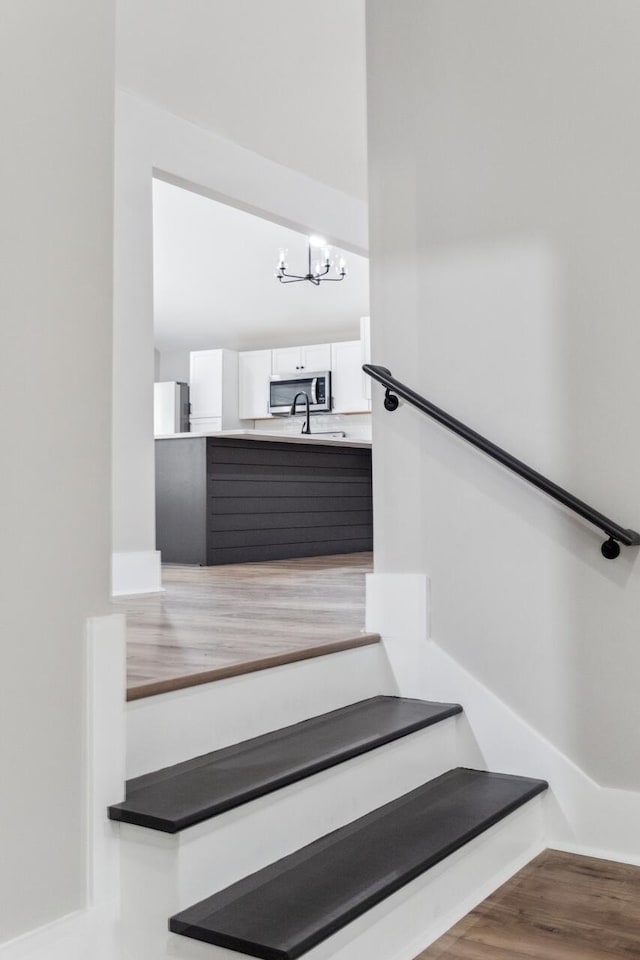 staircase with a chandelier