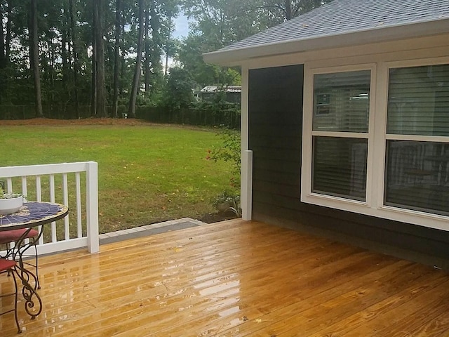 wooden deck featuring a lawn