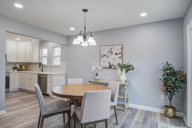 dining area featuring baseboards, recessed lighting, a notable chandelier, and light wood-style floors