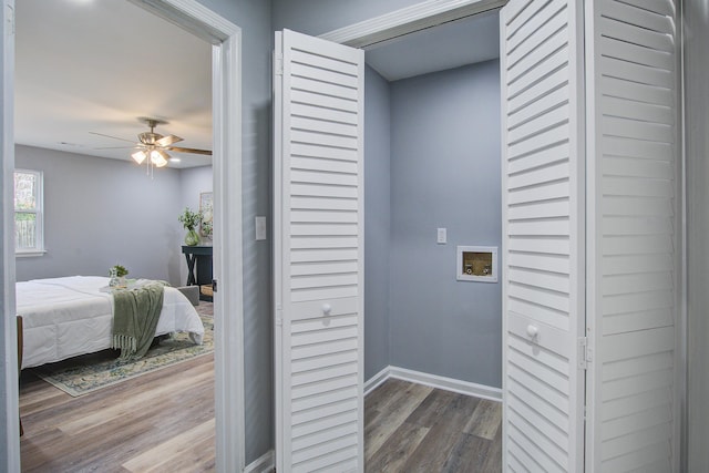 interior space with laundry area, baseboards, ceiling fan, wood finished floors, and washer hookup