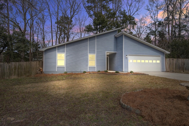 mid-century inspired home featuring a garage, fence, driveway, and a front lawn