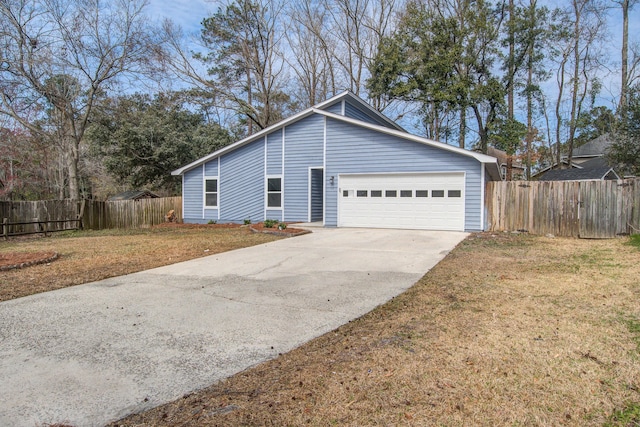 view of front facade featuring a garage, concrete driveway, a front lawn, and fence