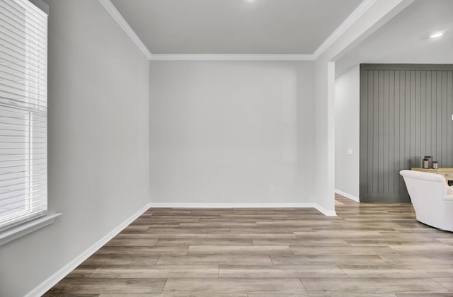 spare room with ornamental molding and light wood-type flooring