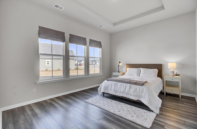 bedroom featuring a tray ceiling and dark hardwood / wood-style floors