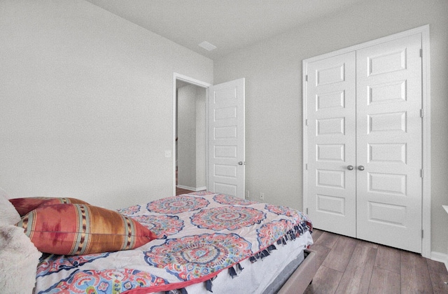 bedroom with light hardwood / wood-style floors and a closet