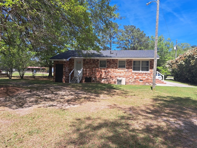 view of front of property with brick siding, a front lawn, crawl space, and entry steps