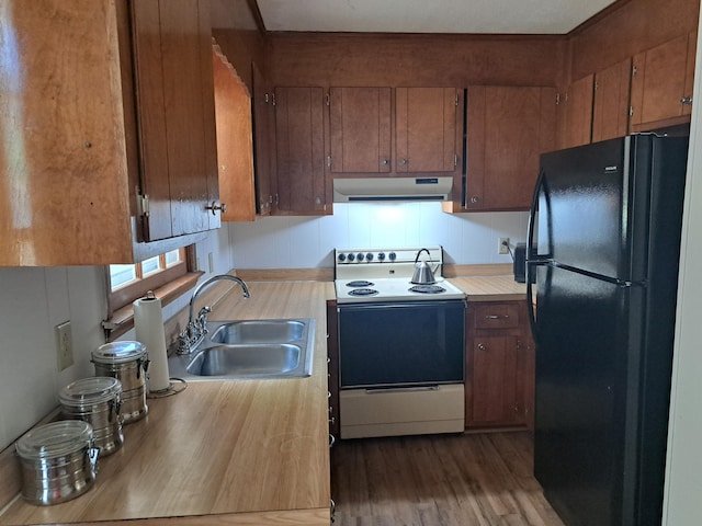 kitchen featuring under cabinet range hood, light countertops, a sink, white electric range oven, and freestanding refrigerator