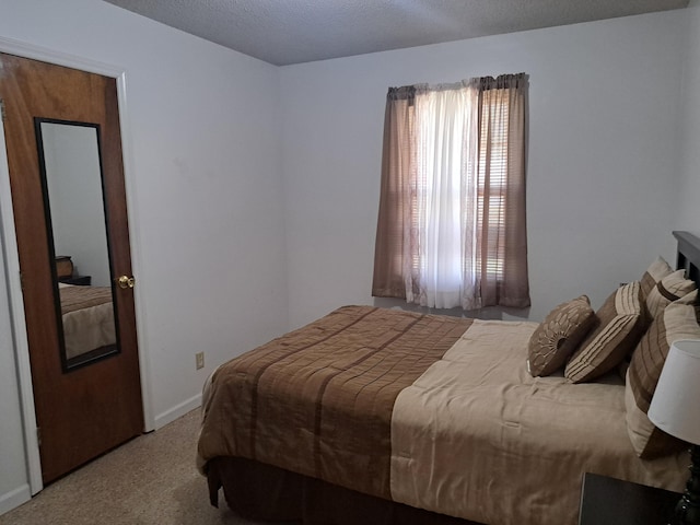 carpeted bedroom with baseboards and a textured ceiling