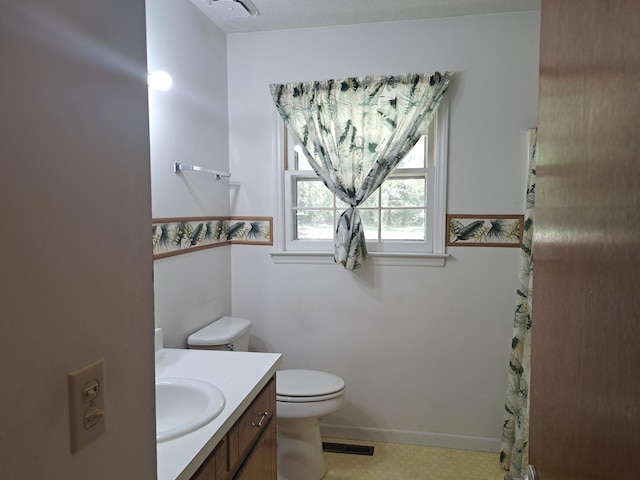 bathroom with baseboards, visible vents, toilet, and vanity