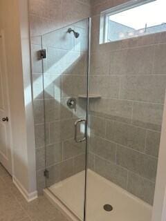 bathroom featuring tile patterned floors and a shower with door