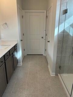 bathroom with tile patterned floors, vanity, and walk in shower