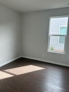 unfurnished room with dark hardwood / wood-style flooring