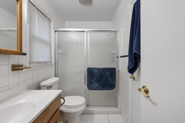 bathroom with walk in shower, tile patterned flooring, toilet, vanity, and tile walls