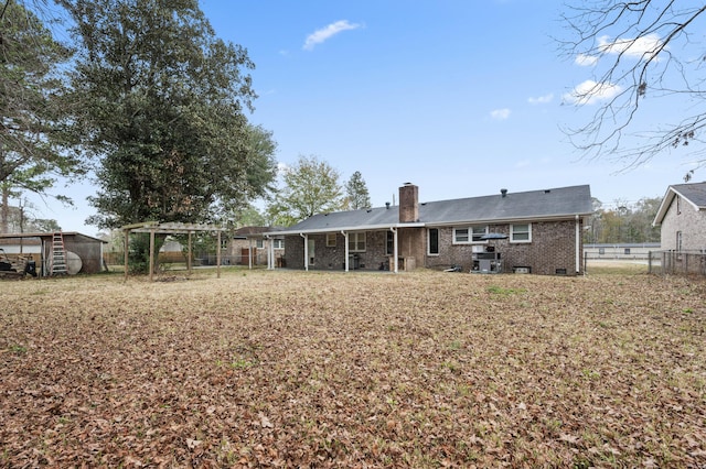 back of house featuring an outbuilding and a pergola