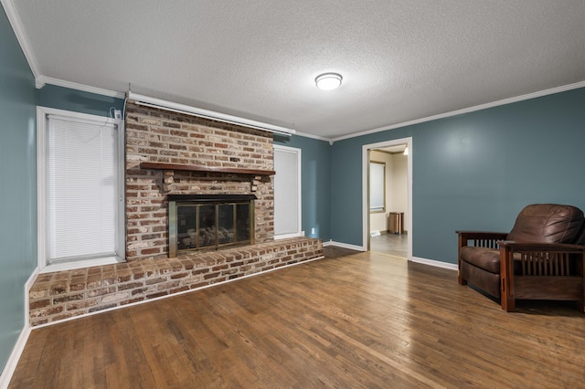 unfurnished living room with a fireplace, a textured ceiling, hardwood / wood-style flooring, and ornamental molding