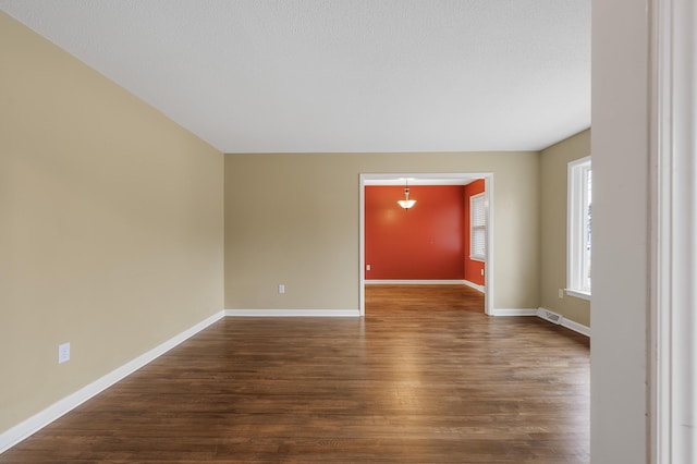 spare room with dark wood-type flooring