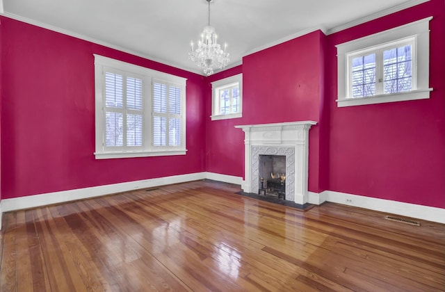 unfurnished living room with hardwood / wood-style flooring, a fireplace, crown molding, and a healthy amount of sunlight