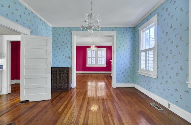 unfurnished dining area with an inviting chandelier, dark hardwood / wood-style floors, and ornamental molding