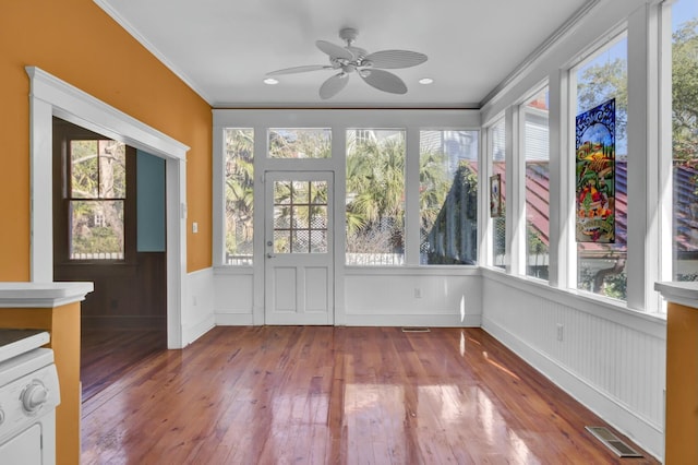 unfurnished sunroom featuring ceiling fan, washer / dryer, and a healthy amount of sunlight