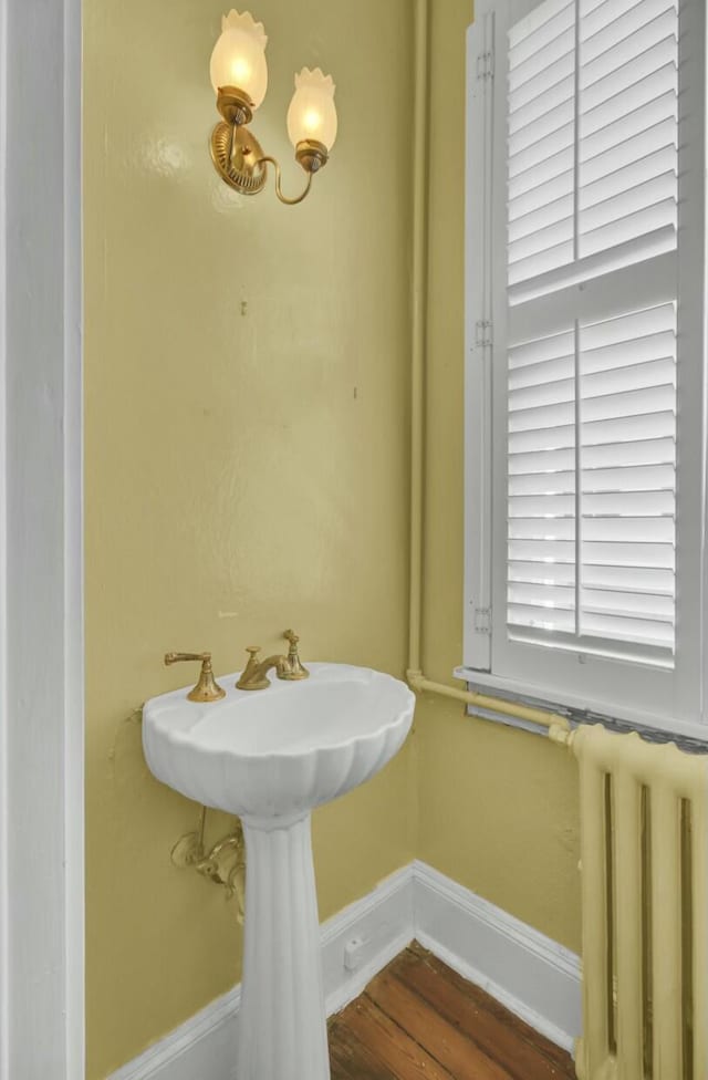 bathroom with hardwood / wood-style floors and radiator