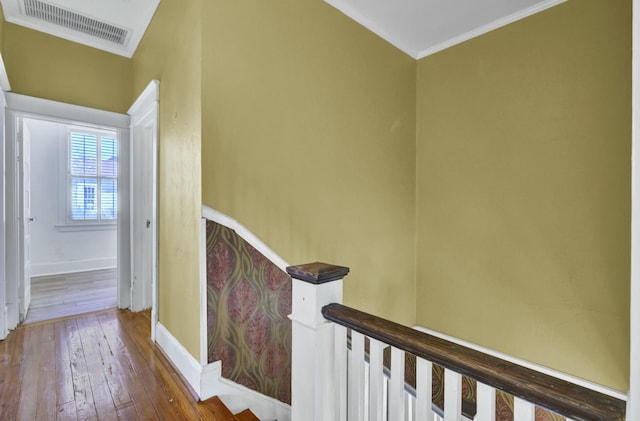 hallway with wood-type flooring and ornamental molding