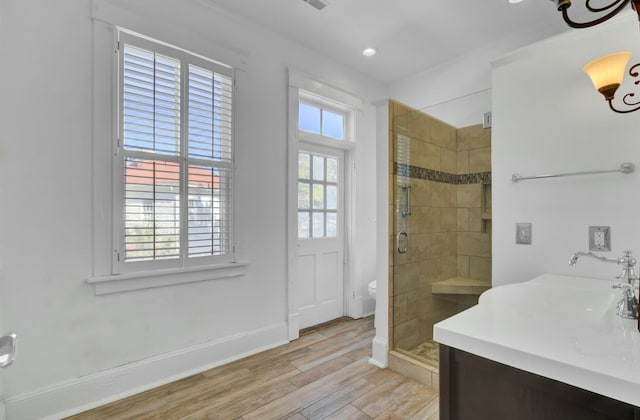 bathroom featuring toilet, a wealth of natural light, a shower with door, and wood-type flooring