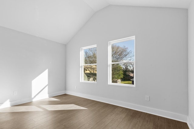 spare room featuring lofted ceiling and light wood-type flooring