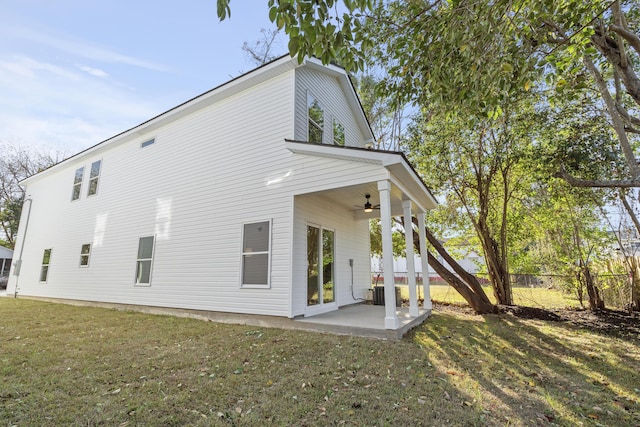 rear view of property with a patio area, ceiling fan, and a yard