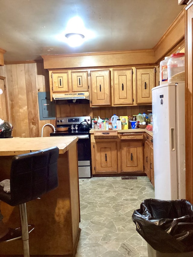 kitchen featuring white refrigerator with ice dispenser, stainless steel electric stove, and wood walls