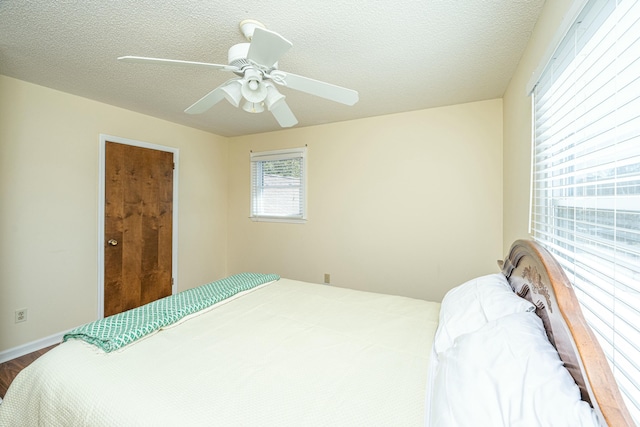 bedroom featuring ceiling fan and a textured ceiling