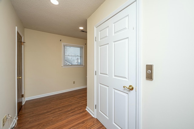 corridor featuring dark hardwood / wood-style floors and a textured ceiling