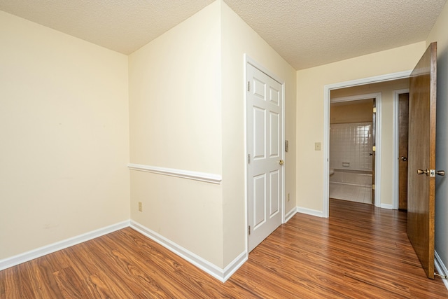 hall with hardwood / wood-style flooring and a textured ceiling