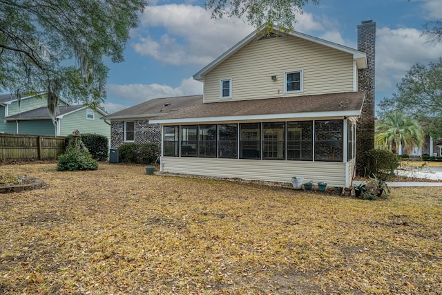 rear view of house with a sunroom and a yard