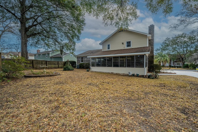 rear view of property featuring a sunroom